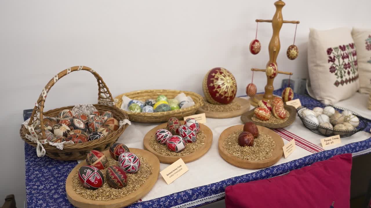 A table with a decorative display of traditional Hungarian Easter eggs in baskets and bowls