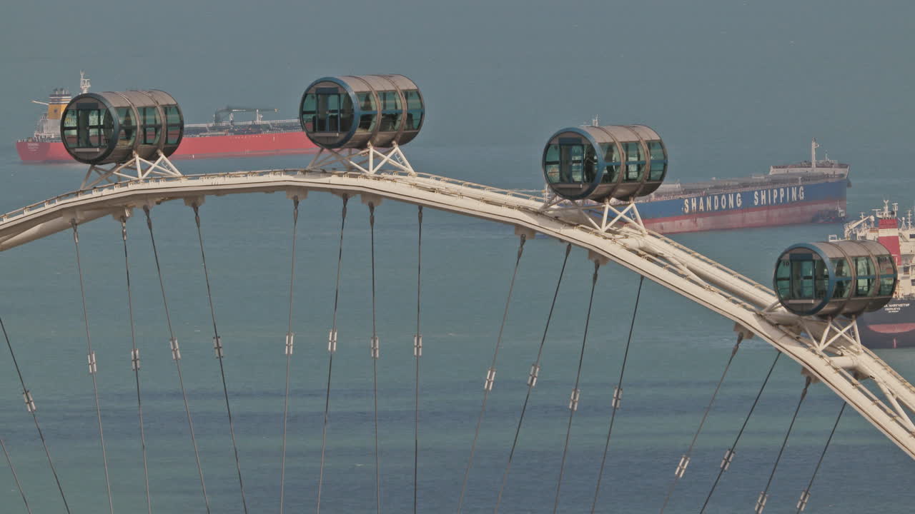 SINGAPORE - 5 MARCH 2025 : container ships waiting in the sea by singapore with observation ferris wheel in foreground