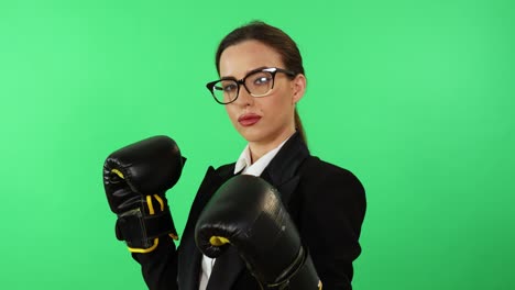 Joven-Empresaria-Con-Gafas-Y-Vestido-Formal-Usa-Guantes-De-Boxeo-Para-Combatir-El-Estrés-Laboral