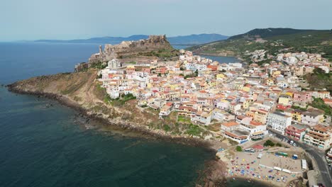 playa de castelsardo y ciudad fortificada en cerdeña, italia - pedestal aéreo de drones 4k arriba