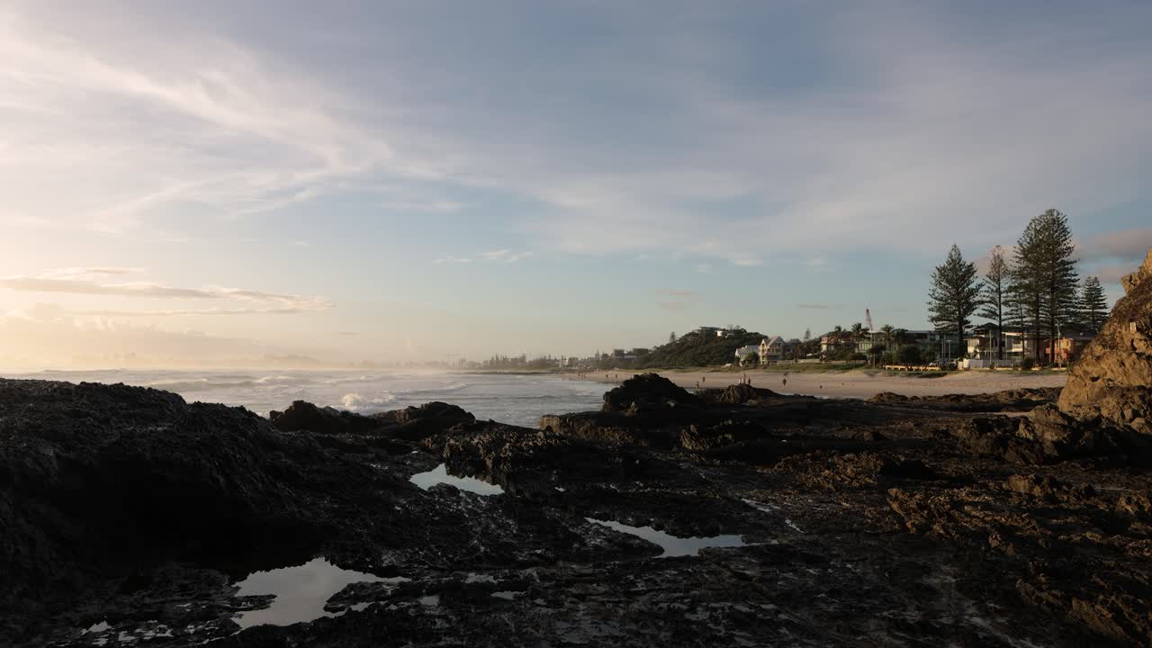 26 de febrero de 2023 - gold coast, queensland, australia: vista desde currumbin beach vikings surf club salvavidas a lo largo de currumbin beach al amanecer