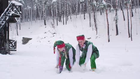funny elves are happy with fresh snow tossing it up. santa claus residence before christmas