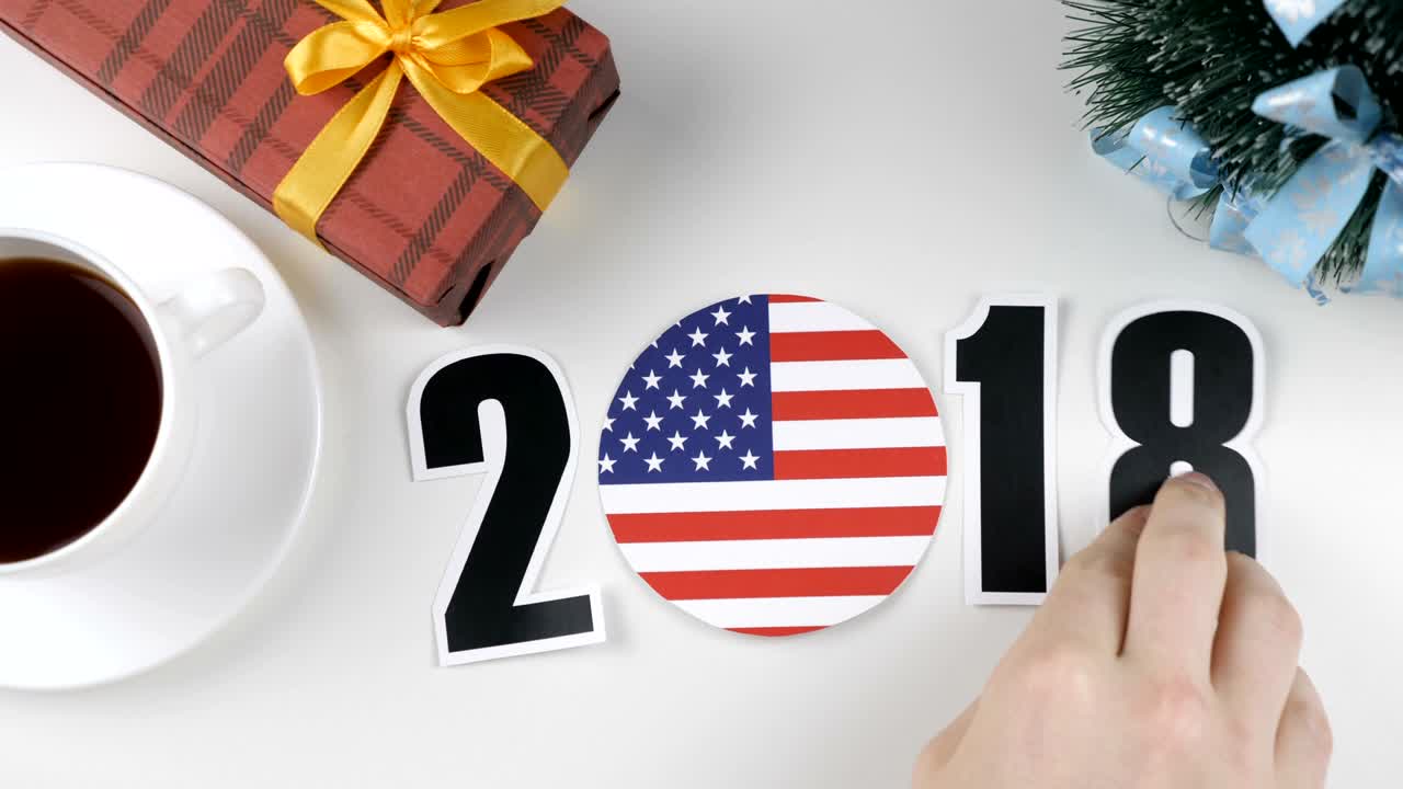 Illustration, new year, male hand changes the year from 2017 to 2018, United States of America flag, cauntry ball.