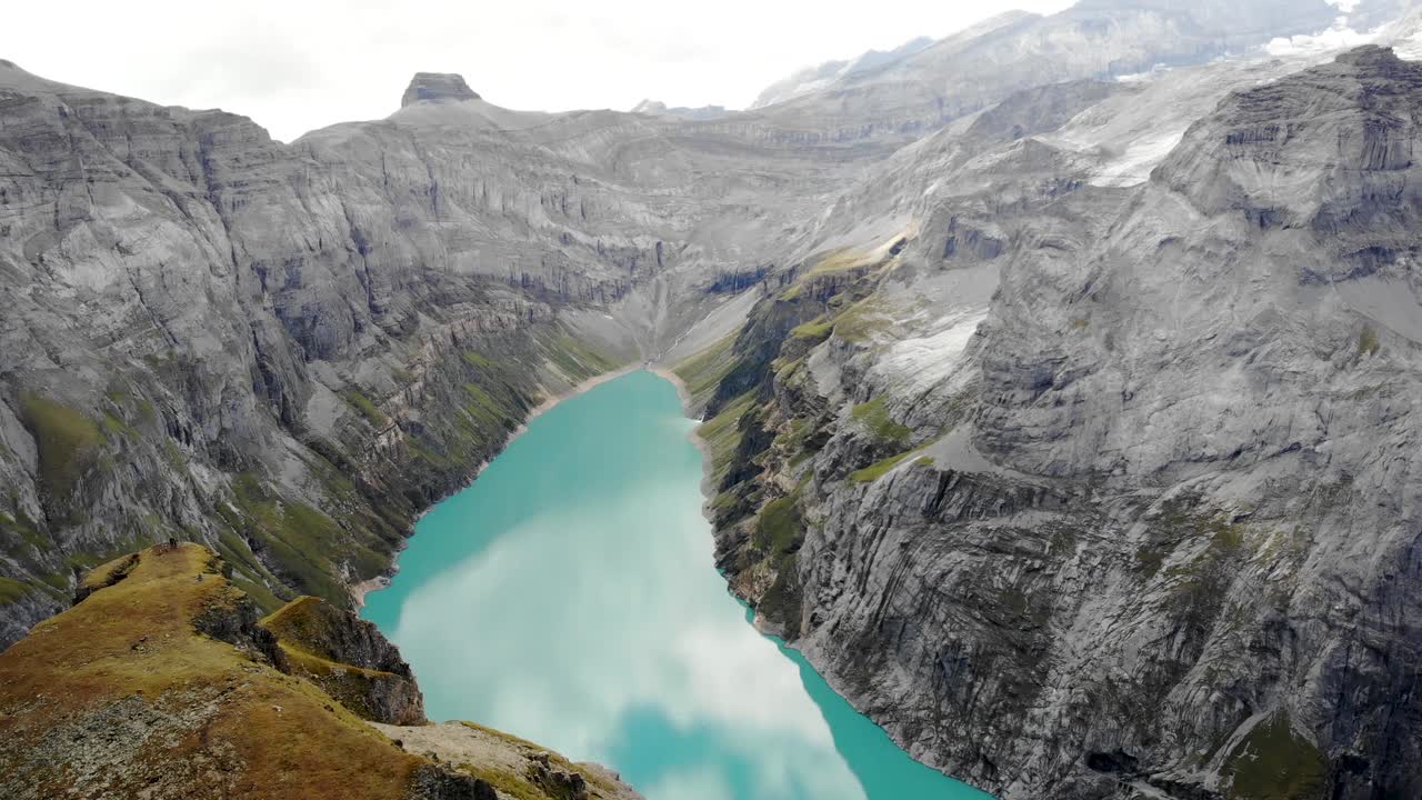 un paso elevado sobre un mirador sobre el lago limernsee en glarus, suiza, con vistas a los acantilados de los alpes suizos y al paisaje en un día nublado