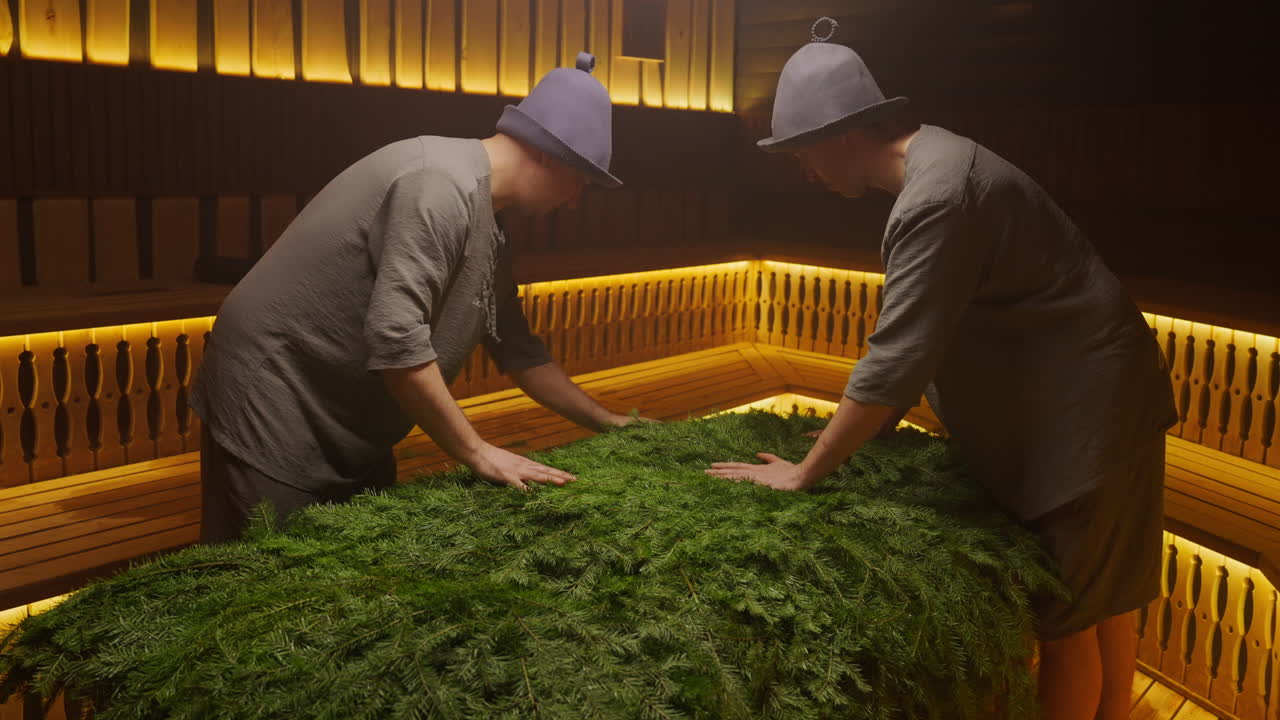 Men Preparing a Sauna with Fir Branches