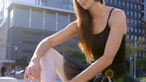 female ballet dancer tying the ribbon on her ballet shoes 4k