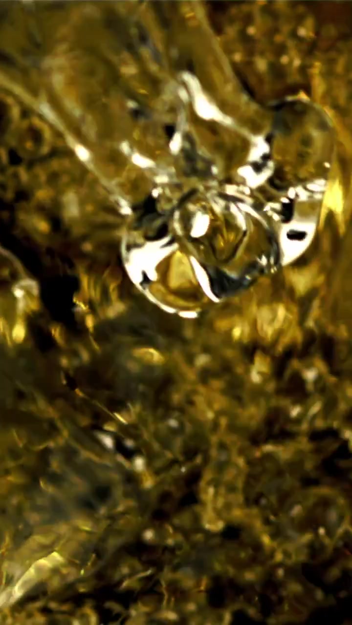 Primo piano di liquido viscoso dorato che si versa con bolle