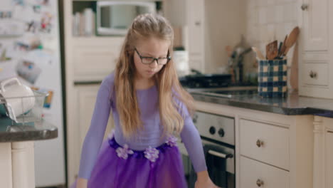 una bailarina feliz bailando en la cocina con un tutu púrpura divirtiéndose realizando movimientos de baile divertidos disfrutando de la celebración del fin de semana en casa