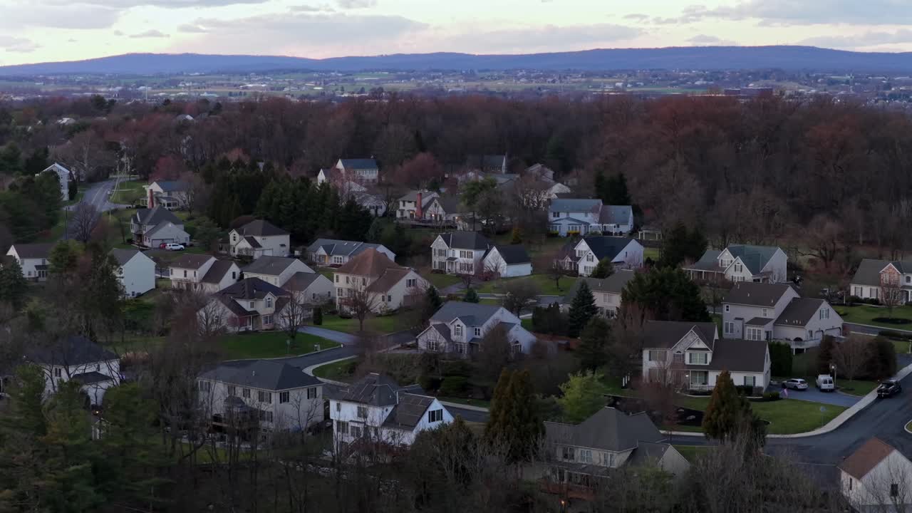 Luftfoto af et forstadskvarter i Pennsylvania ved solnedgang, med enfamiliehuse, træomkransede gader og rolige boligomgivelser i det tidlige forår. Luksushjem i USA