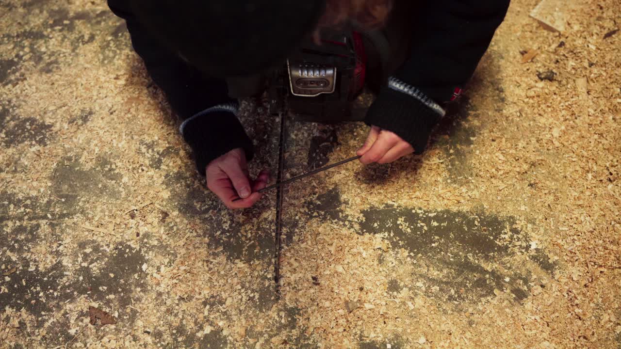 한 남자 가 체인 의 가장자리 를 날카롭게 하고 있다 - 근접적 인 모습