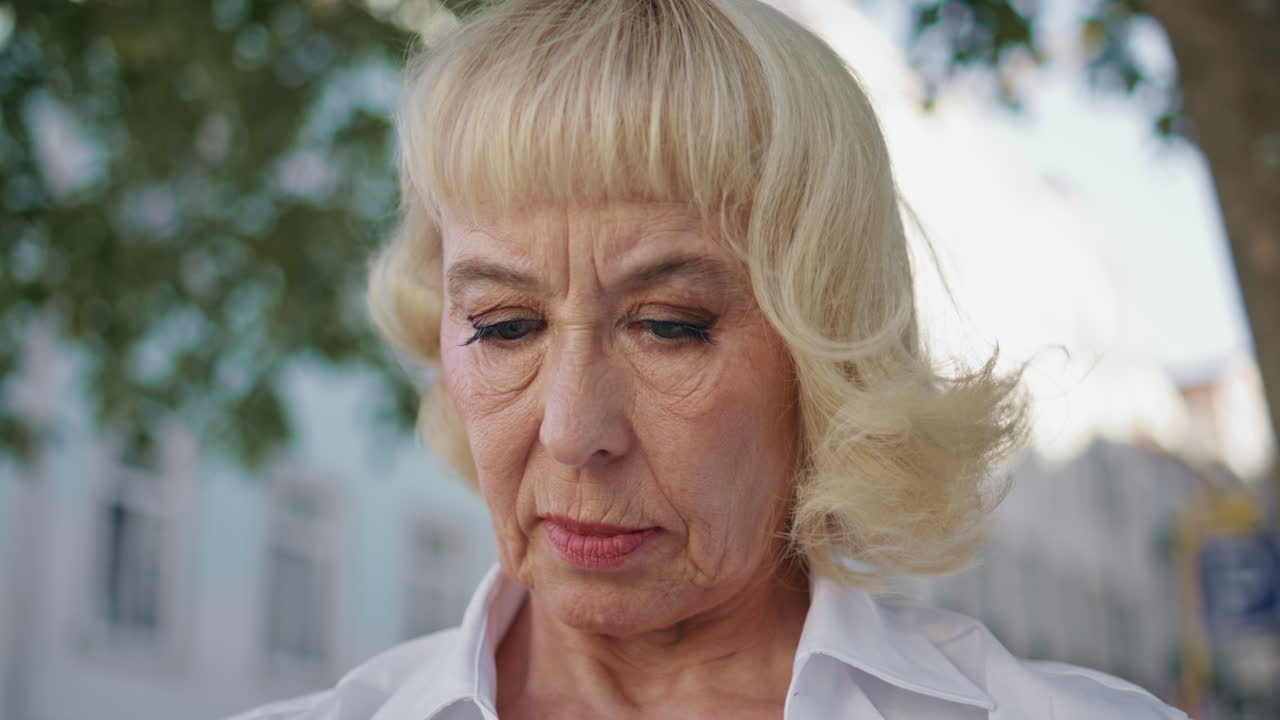 una anciana de primer plano mirando el periódico relajándose al aire libre. pensionado leyendo.