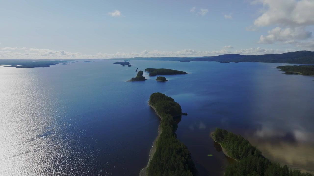 Ripresa aerea in tracking di isole boscose sul lago Pielinen a Koli, giornata di sole