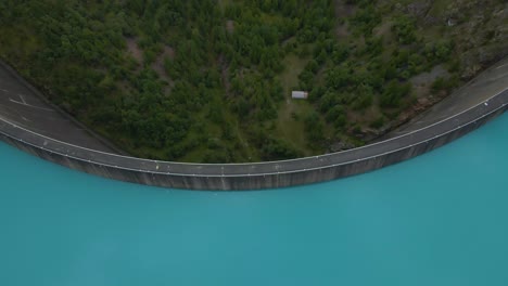 drone shot flying backwards while panning up over the place moulin dam in the aosta province in italy