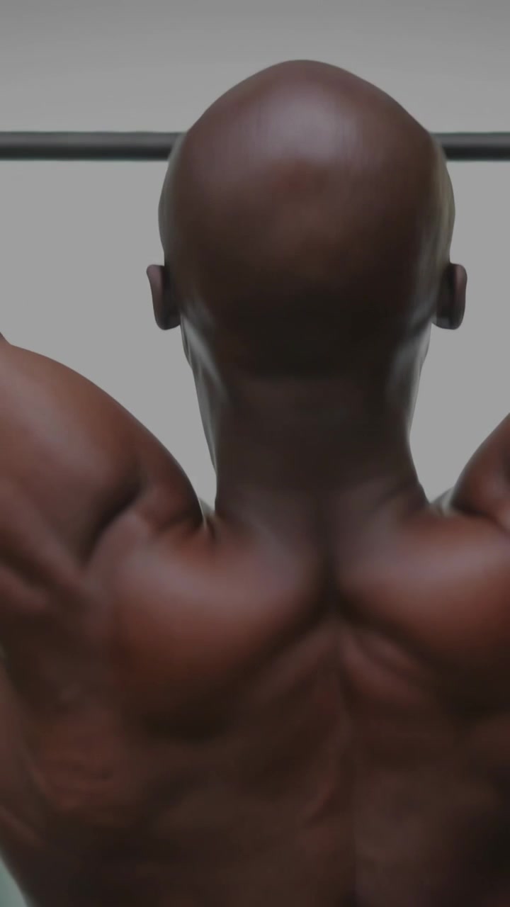 Video verticale: Un uomo fa una trazione in una palestra, afferrando la sbarra e avviando grafici in tempo reale per il monitoraggio.