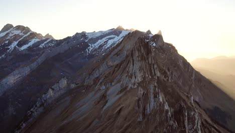 sobrevuelo aéreo sobre schaefler en appenzell, suiza al atardecer con movimiento inverso sobre los acantilados y la ruta de senderismo