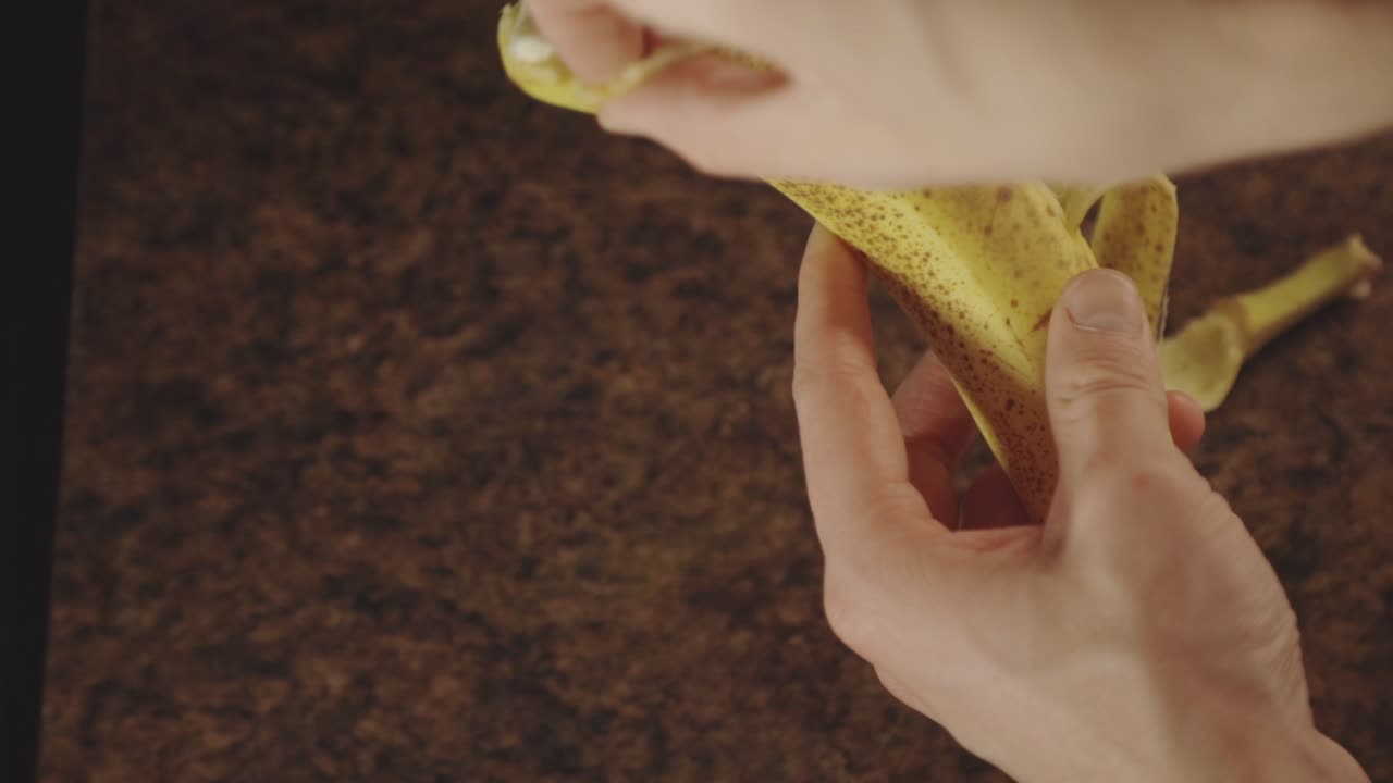 persona pelando plátano maduro. - angulo alto