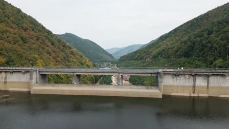 big sea and dam with an even bigger valley and forest after it, carpathians, romania, europe, drone, summer