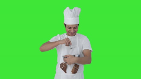 feliz chef profesional indio golpeando la harina pantalla verde