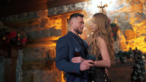 couple in love on date. woman and man in love drinking red or rose wine smiling happy flirting inside. young caucasian man and woman well dressed.