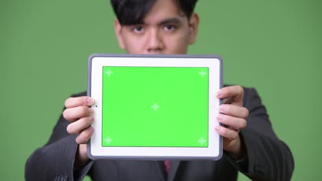 joven empresario asiático guapo usando una tableta digital
