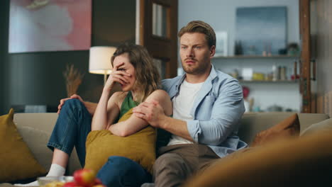 Fearful-lovers-horror-movie-watching-at-evening.-Frightened-woman-closed-face