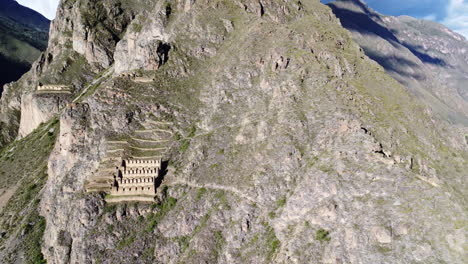 Drone-overview-of-trail-leading-to-historic-town-site-of-Ollantaytambo-cut-out-of-hillside-in-Peru