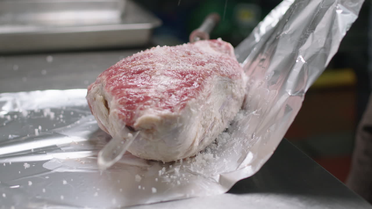 브라질 고기 스피어 준비, 포일로 포장하기 전에 소금으로 고기를 향신료