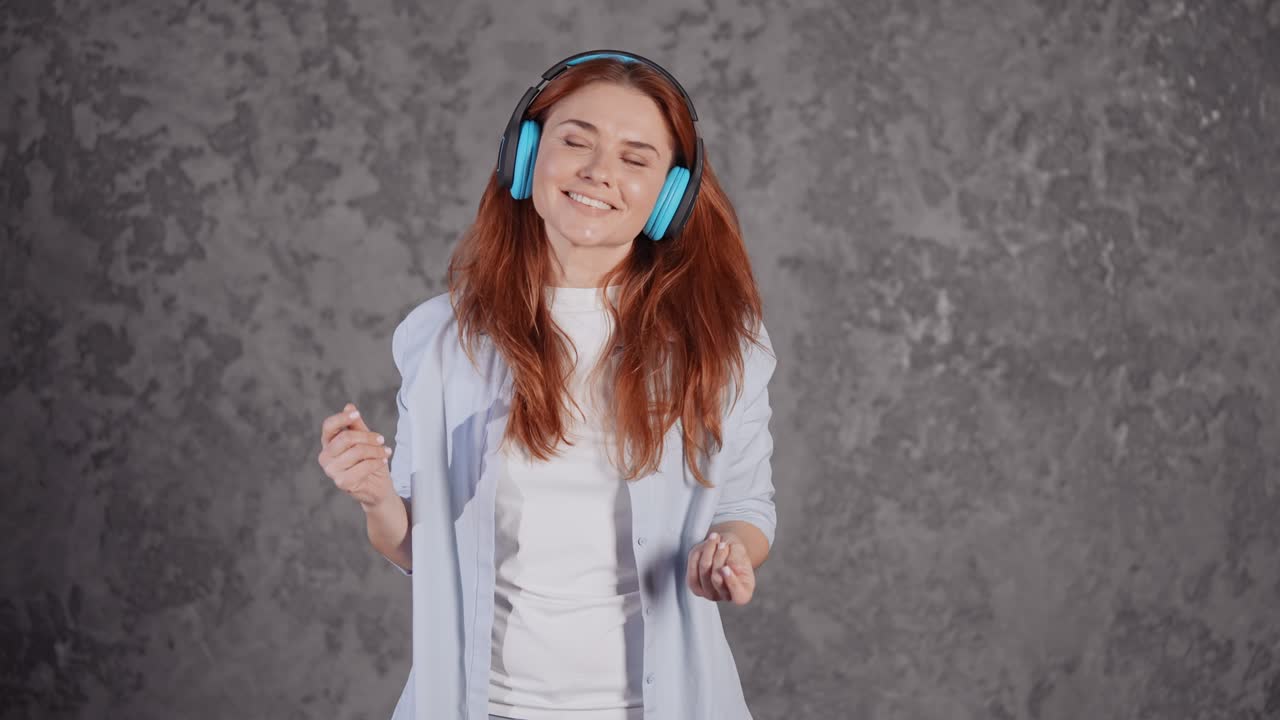 young red headed female with earphones dances