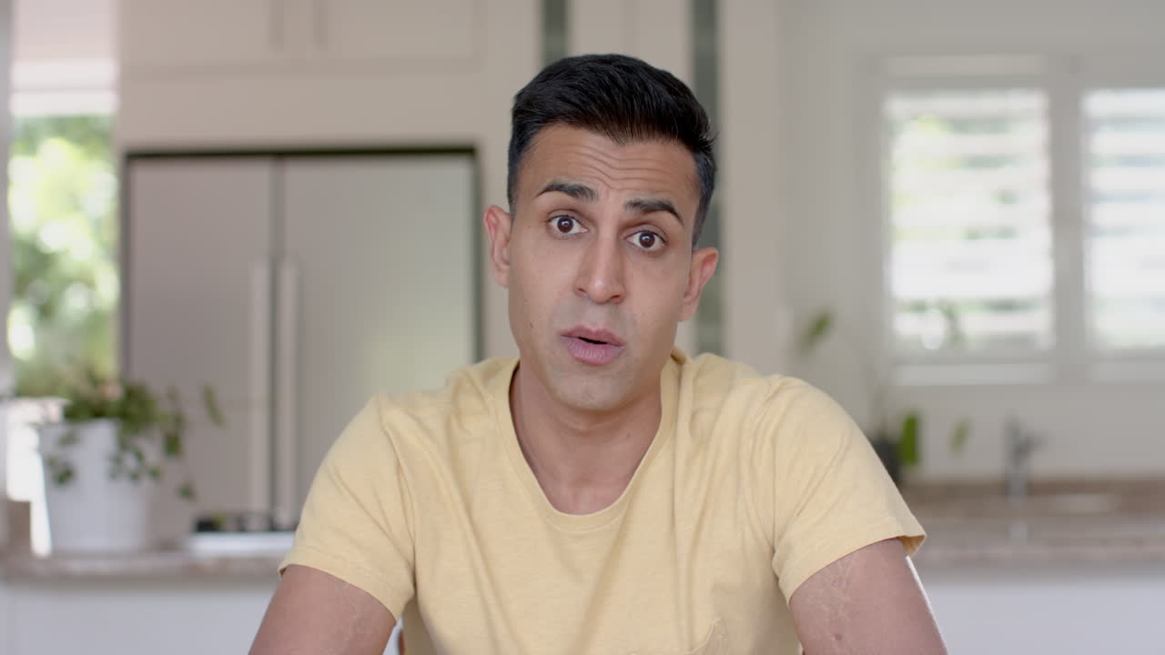 집중적이고 진지한 두 인종의 남자가 비디오 통화를 하고, 집에서 부에서 이야기하고, 느린 동작을 하고