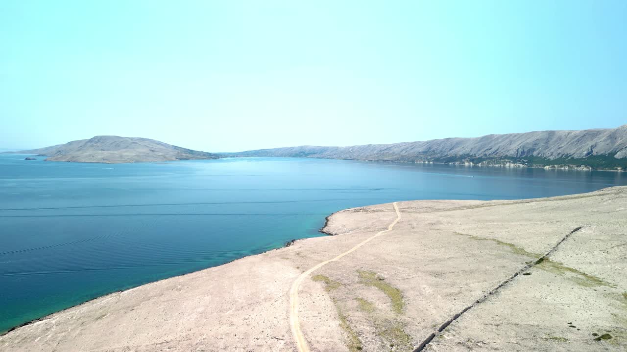 An aerial footage over white stoney, barren island and deep blue Adriatic on island Pag, Croatia in summer