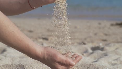 sand falling from hand in slow motion on a beach. vacation and travel concept. shot on super slow motion camera 1000 fps