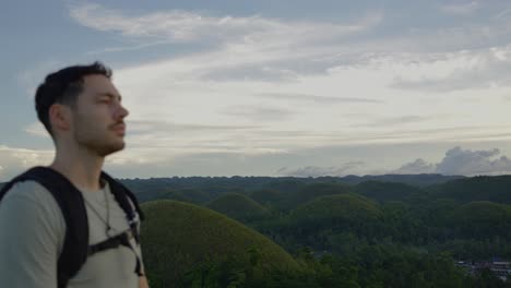 explorer man walking by bohol chocolate hills in the philippines