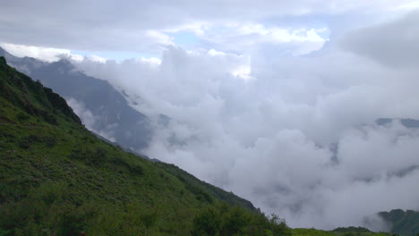 A-lady-trekker-stands-on-a-hill-looking-serene-natural-landscape-Nepal-drone-shot-4K