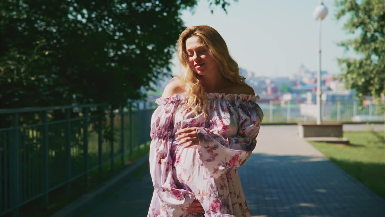Mulher Grávida Feliz Caminhando em um Parque Ensolarado