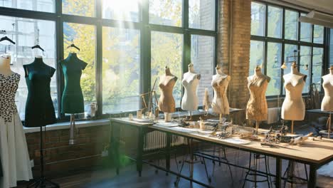 brightly lit fashion studio with dress forms and creative workspace