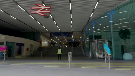 lone railway key worker entering an empty cannon street station, central london, uk