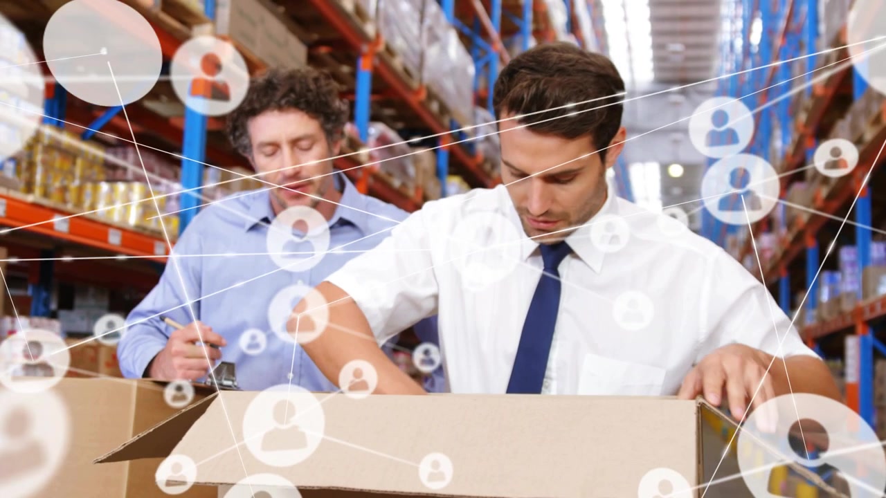 Packer opening box while supervisor writing on clipboard in warehouse, network icons expanding