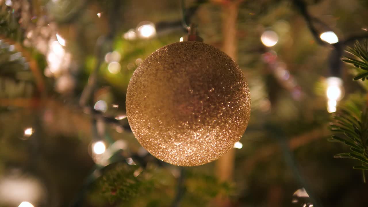 bola de adorno de oro en el árbol de navidad con luces bokeh en 4k
