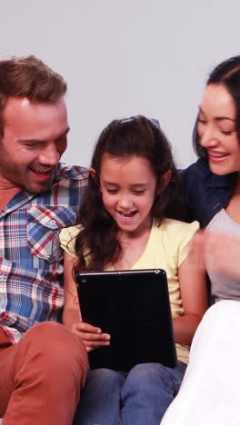 familia linda con hija usando tableta