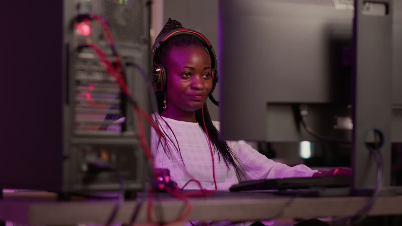 Handheld shot of african american streamer talking on headset while online playing first person shooter
