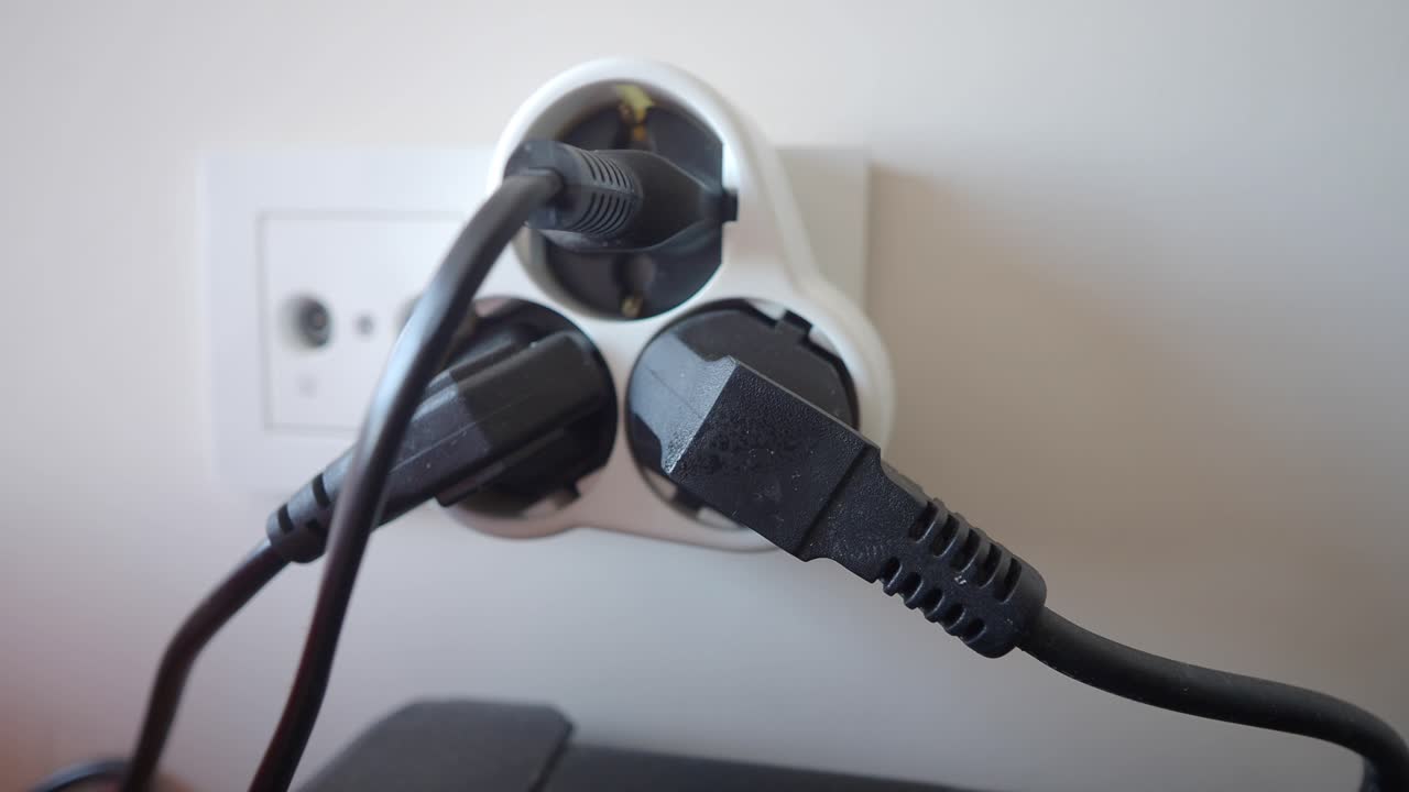 primer plano de una tira de alimentación blanca con múltiples enchufes y cables