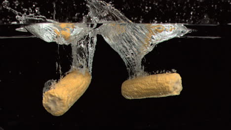 corn cobs dropped into water in super slow motion