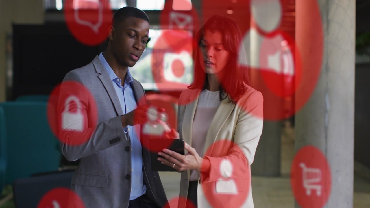 Man pointing and woman holding tablet, reviewing business app while red icons overlaying subjects