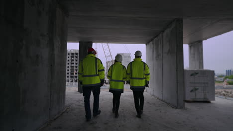 group of civil engineers are walking in under-construction building foremen and female architect