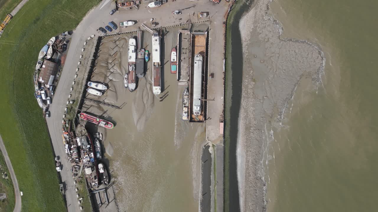 낮은 조류 동안 정박한 선박과 함께 마리나 위로 내려오는 공중 새 눈