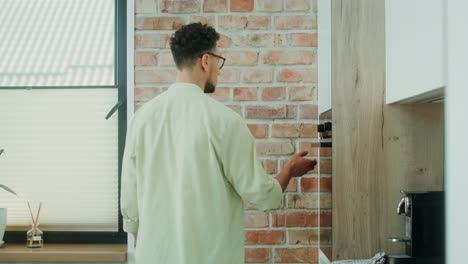man in kitchen interacting with appliances
