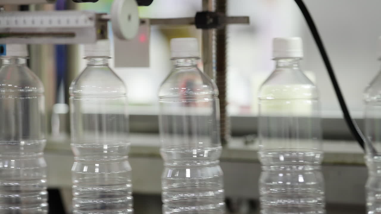 Clear Plastic Bottles Moving on a Production Line in a Factory