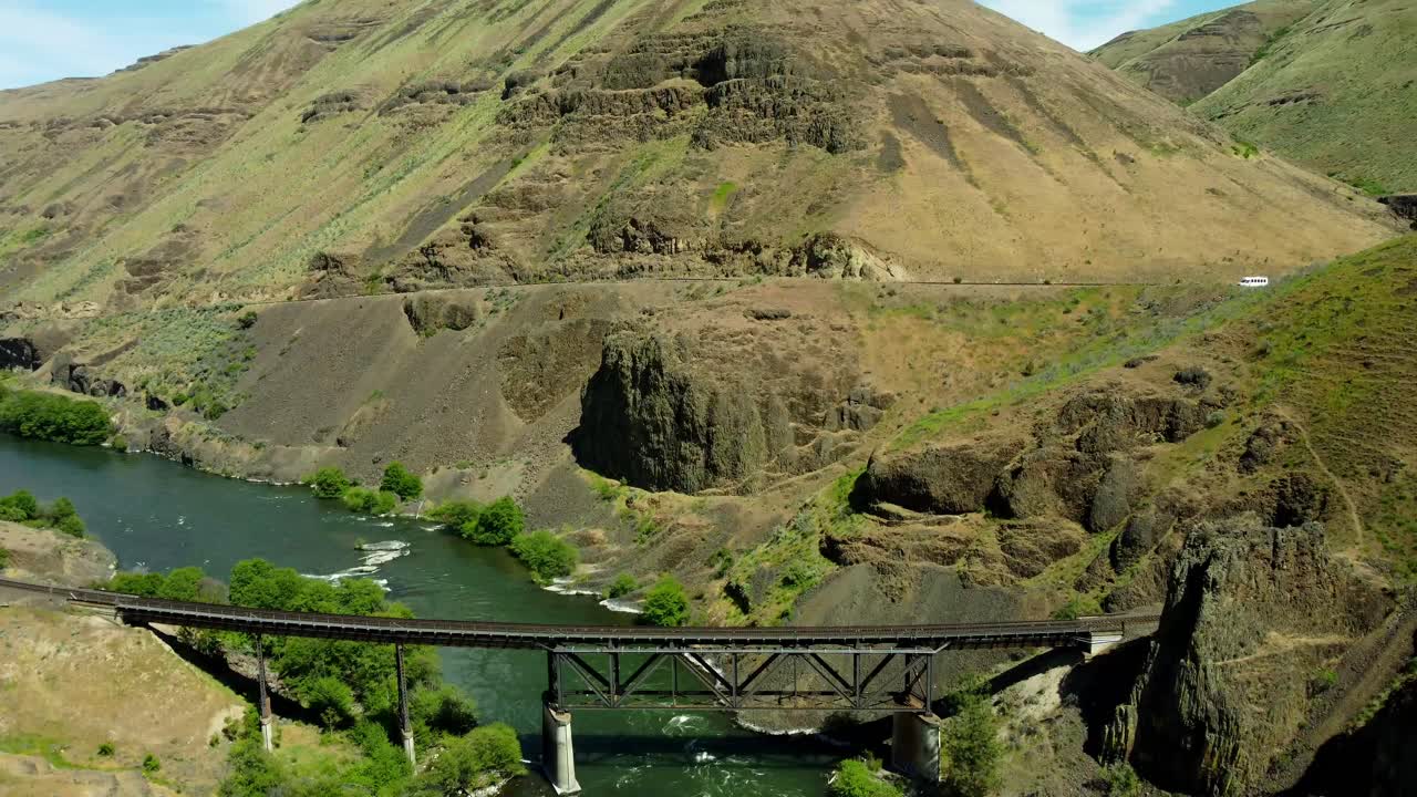 US, Oregon, Maupin, Deschutes River, 2025-05-08 - Drone view on the Deschutes River of a train bridge at Twin Crossings which is two bridges and a tunnel. In north central Oregon in spring