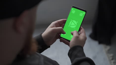 Smartphone with vertical green screen chroma. Mockup. Telecommuting, sending and receiving messages. Close-up.