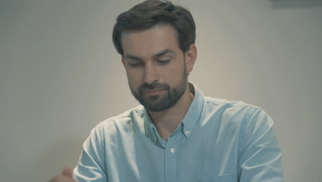 portrait of young handsome man with beard and blue eyes putting on a face mask and looking at camera